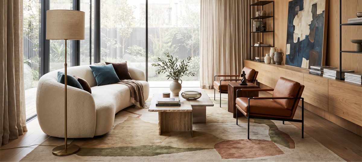 Tendencias en decoración de salón Salón moderno con sofá curvo, iluminación de diseño, muebles de madera y decoración en tonos neutros siguiendo las últimas tendencias de interiorismo.