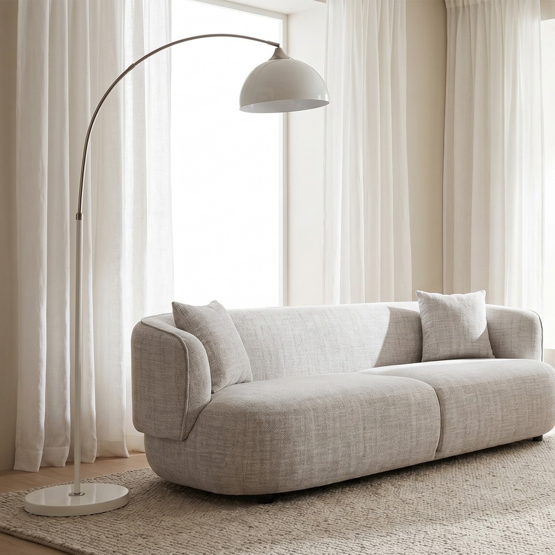 Lámpara de pie moderna para salón minimalista Lámpara de pie arco blanca junto a sofá curvo beige en salón moderno minimalista
